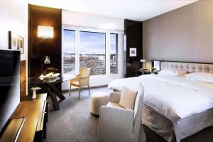柏林柏林君悦酒店的配有一张床、一张书桌和一扇窗户的酒店客房
