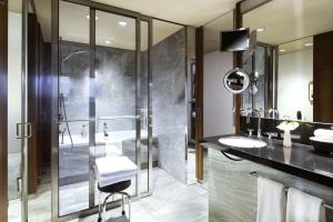 柏林柏林君悦酒店的一间带玻璃淋浴和水槽的浴室
