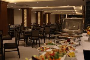 卡尔巴拉Coral Hotel Karbala的用餐室配有桌椅和食物