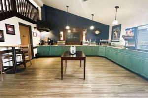 Menominee梅诺米尼阿美瑞辛酒店的一个带绿色橱柜和一张桌子的大厨房