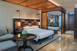 沙努尔Andaz Bali - a Concept by Hyatt的一间卧室配有一张床,浴室设有浴缸