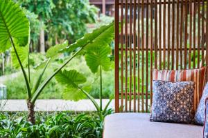 沙努尔Andaz Bali - a Concept by Hyatt的花园内带枕头的沙发