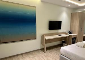 维沙卡帕特南World Inn Hotel的酒店客房设有一张桌子和一台墙上的电视。