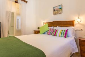 马略卡岛帕尔马Casa Vileta的卧室配有一张带彩色枕头的大型白色床。