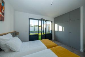 La NoueMaison familiale neuve avec piscine chauffée的卧室配有一张白色大床和黄色毯子