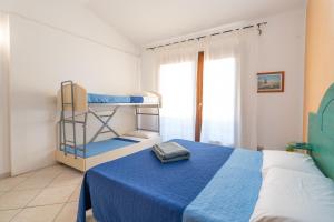 巴德希Le corti del turchese的一间卧室配有两张双层床和蓝色毯子。