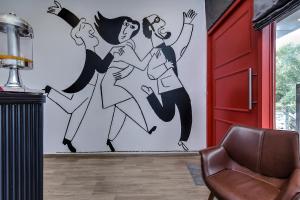 海得拉巴Townhouse RCC PARK VIEW INN的一张墙上的三个女人在房间里跳舞的壁画