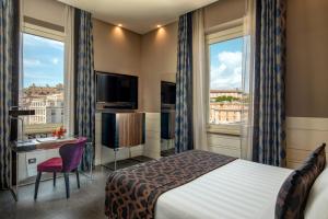 罗马The Glam的酒店客房设有一张床、一张书桌和两个窗户。