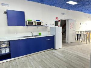 罗萨斯Agi Gloria Rooms的厨房配有蓝白台面和电器