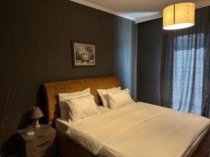 地拉那Misk Hotel & Resort的一间卧室配有带白色床单和枕头的床。