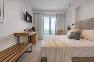 埃雷特里亚Amaronda Resort & Spa Eretria的一间卧室配有一张床、一张长凳和一个窗户。