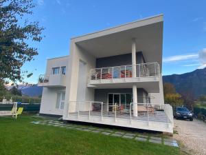 卡尔多纳佐B&B A Un Passo Dal Lago, Caldonazzo的带阳台和汽车的大型白色房屋