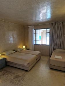 艾宰穆尔L'Oum Errebia的一间卧室设有两张床和窗户。