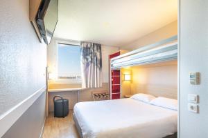 圣康坦法拉维耶B&B HOTEL Lyon Aéroport Saint-Quentin-Fallavier的酒店客房设有床和窗户。