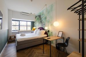 乌得勒支Badhuis Hotel的一间卧室配有一张床和一张桌子及椅子