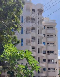 蒙巴萨Studio Apartment Nyali的带阳台和树木的白色公寓大楼