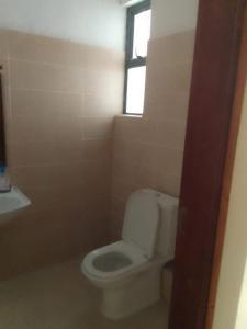 蒙巴萨Studio Apartment Nyali的一间带白色卫生间的浴室和窗户。