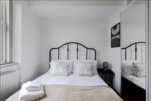 伦敦Primrose Hill Charming 1-Bed Flat的白色卧室配有一张带白色枕头的大床