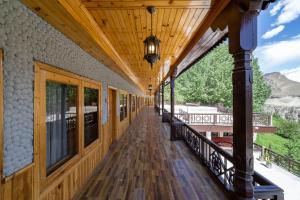 罕萨Roomy Daastaan Hotel, Karimabad Hunza的一个带顶棚的门廊,拥有木制天花板