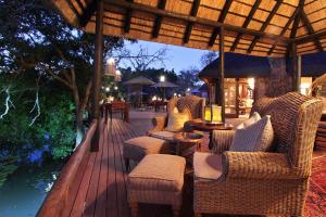 威尔吉旺登禁猎区Ndlovu Safari Lodge的木制甲板配有桌椅和遮阳伞