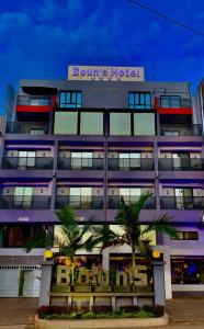 雅温得Boun's Hotel的一座建筑,前面有棕榈树的酒店