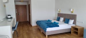 米科瓦伊基力士别墅旅馆的一间卧室配有一张带蓝色床单的大床