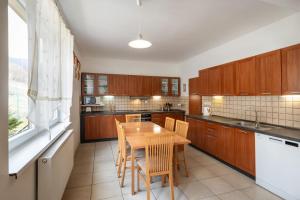 ProsiekVILLA SVORAD - Prosiecka dolina的厨房配有木桌和木橱柜。