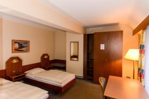 卢森堡APPART-HÔTEL MARCO POLO的酒店客房设有两张床和一张桌子。