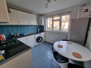 伦敦2 Bedroom Apartment in Kentish Town的一个带桌子和水槽的小厨房