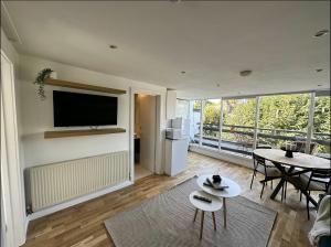 伦敦Primrose Hill Apartment with Balcony的一间带电视和桌子的客厅