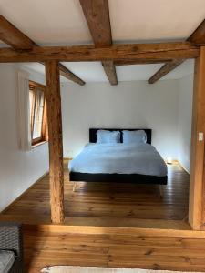 圣加仑Alpen Oase Natur的一间卧室配有一张铺有木地板并配有木梁的床。