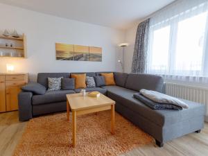 宾茨Wohnpark Stadt Hamburg - Apt. 27的客厅配有蓝色的沙发和桌子