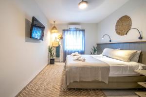 Gadotכפר הנופש קיבוץ גדות Kibbutz Gadot Galilean Resort的卧室配有一张床,墙上配有电视。