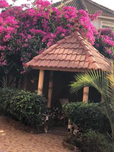 RufisqueRésidence Keur Fleurie Sénégal的凉亭,房子里摆放着粉红色的鲜花