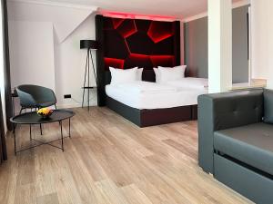 克桑滕DORMERO Hotel Xanten的卧室配有1张床、1张桌子和1把椅子