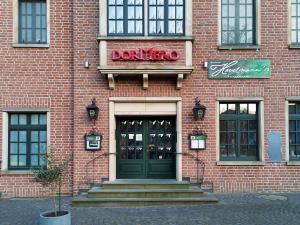 克桑滕DORMERO Hotel Xanten的砖砌的建筑,有门,有甜甜圈店