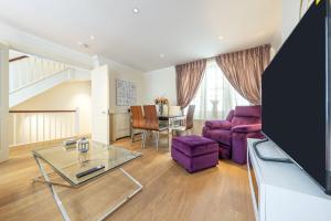 伦敦The Shepherd Residence的客厅配有紫色沙发和桌子