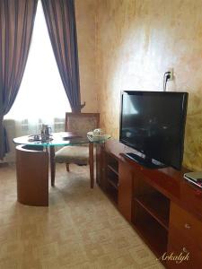 Arqalyqгостиница Аркалык的客厅配有平面电视和桌子。