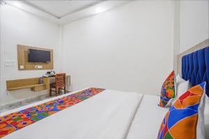 TājganjFabHotel Taj Avenue的白色的客房配有一张床和一张书桌