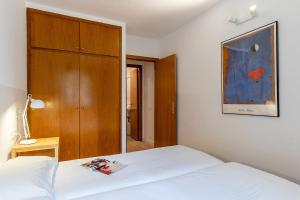 巴塞罗那AB Cozy Flat in El Born的卧室配有白色的床和木制橱柜。