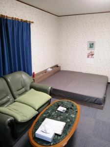 泉大津市Minpaku Yamamoto - Vacation STAY 13870的客房设有床、沙发和桌子。