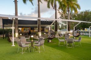 布里奇敦The Rockley by Ocean Hotels - Breakfast Included的一个带桌椅的庭院,棕榈树