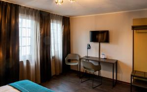 美因河畔法兰克福Trip Inn Hotel Sachsenhausen的酒店客房配有一张床和一张书桌及一台电视