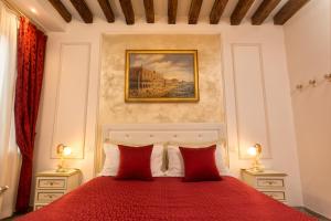 威尼斯CàPatron的一间卧室配有一张红色的床和两盏灯