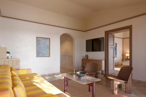 坎尼吉翁Aethos Sardinia的客厅配有沙发和桌子