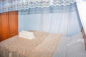 Homa BayThe Bay House的卧室配有带白色窗帘的床和窗户。