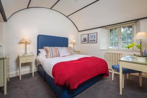 托基Cary Arms & Spa的一间卧室配有一张床铺,床上铺有红色毯子