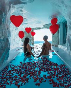 米克诺斯城塔吉甲沃米科诺斯酒店的一对夫妇站在水面上,心地在地板上