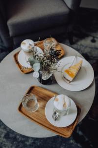 巴特法兴格Boutique Hotel Diana的木盘上带盘子和杯子的桌子