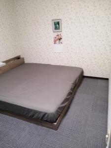 泉大津市Minpaku Yamamoto - Vacation STAY 13870的墙上有两张照片的房间的一张床位